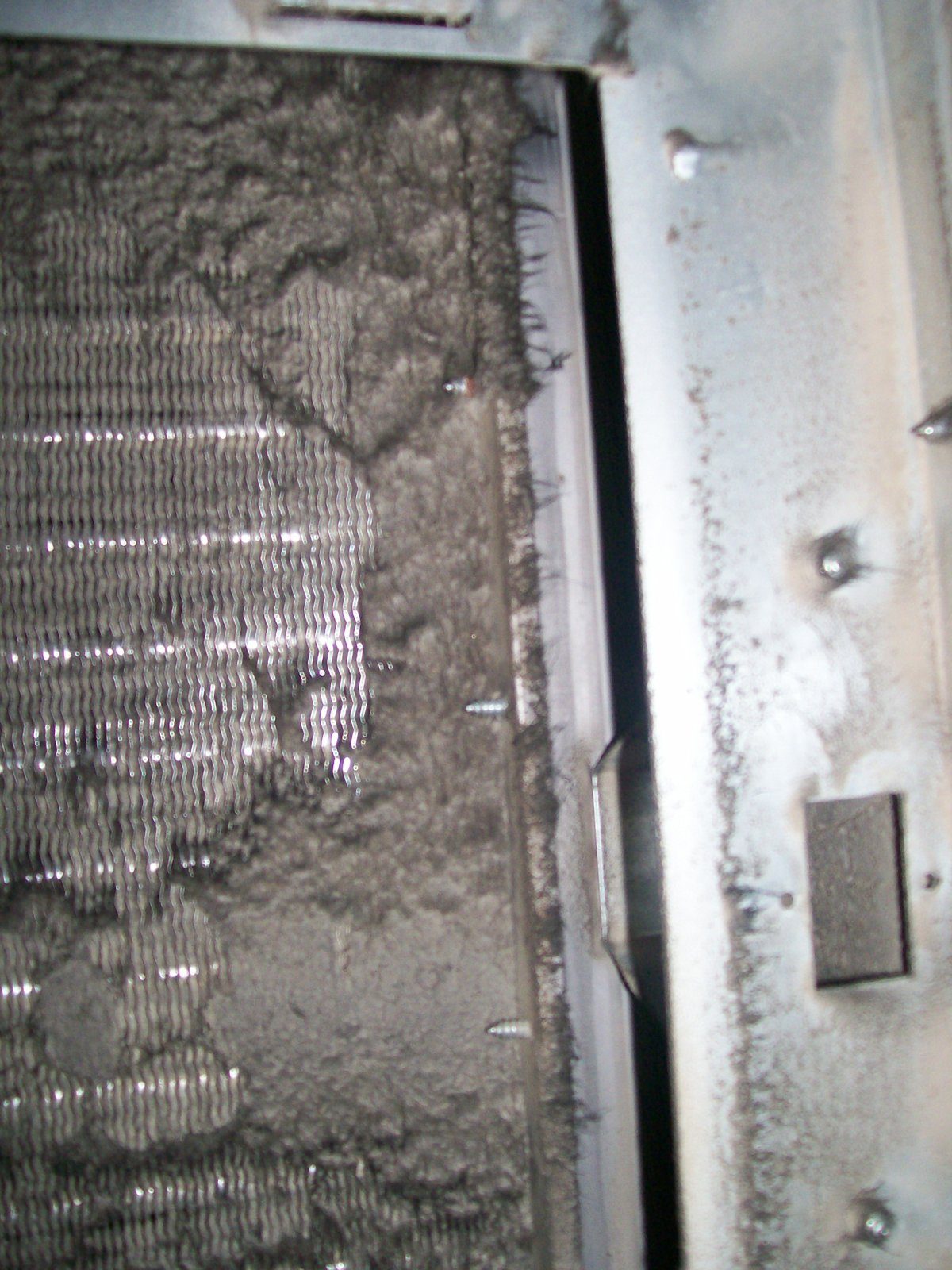 Dirty, neglected HVAC component covered in caked-on debris