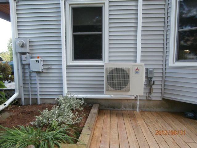 Mitsubishi ductless outdoor unit installed beside a backyard deck