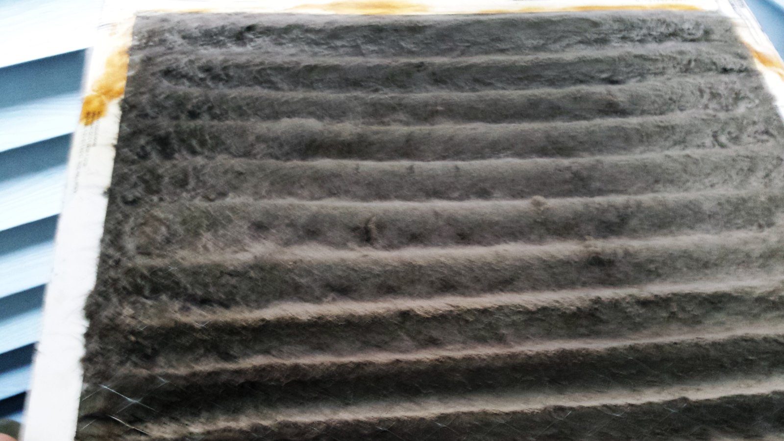 Neglected, dirty HVAC air filter caked with dust and debris