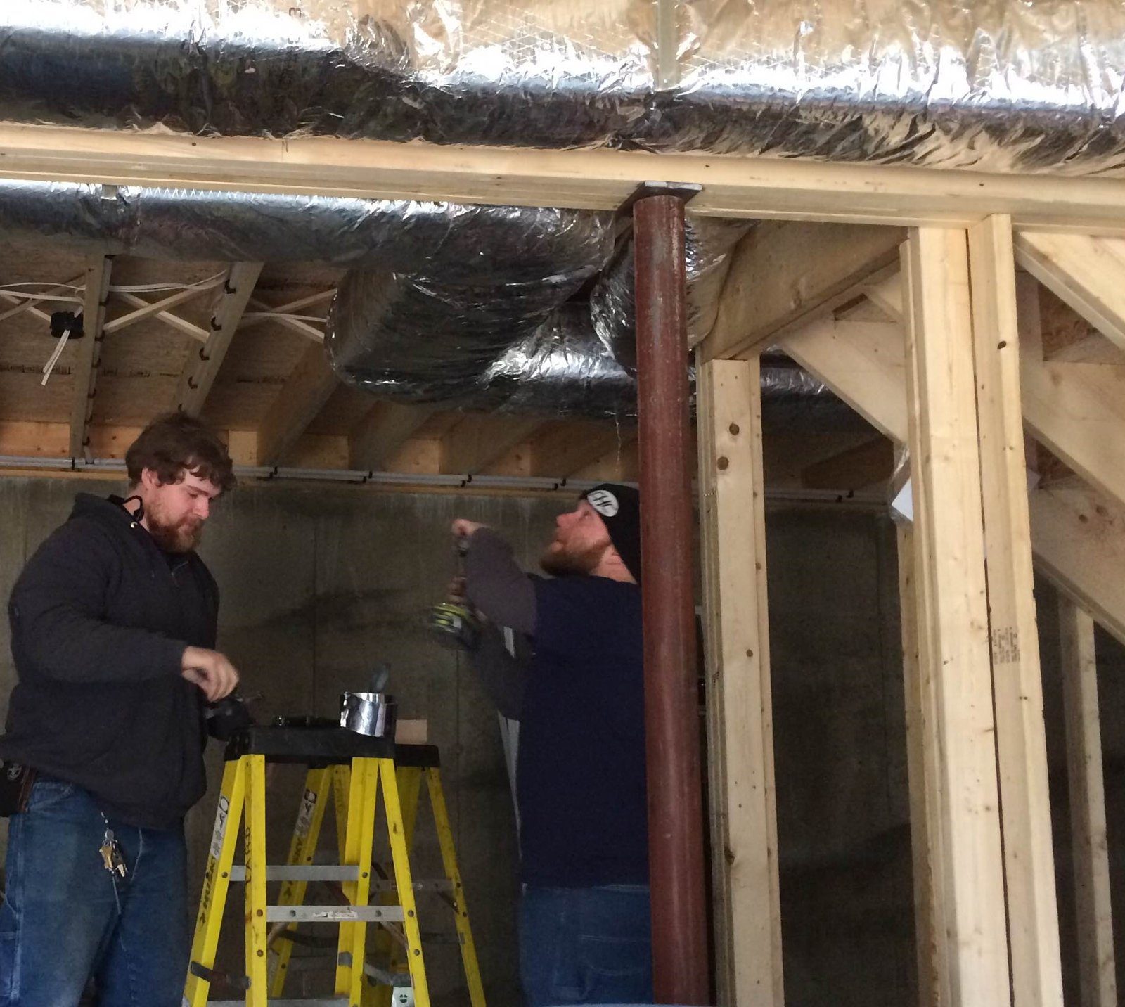 Nick and Dave installing ductwork on a new construction project