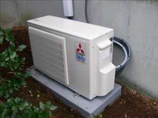 Mitsubishi ductless mini-split outdoor condenser unit on a concrete pad