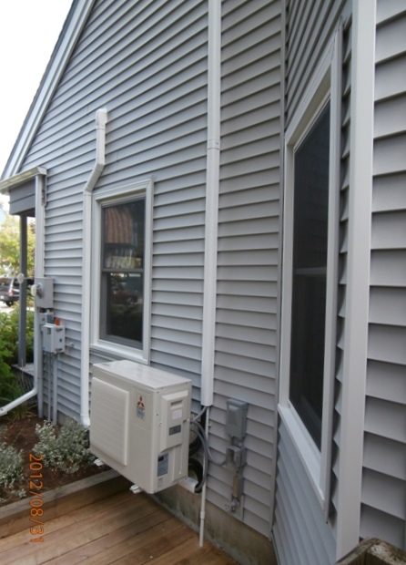 Ductless line set neatly run along the vinyl siding of a home